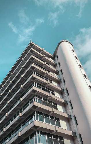 condo low-angle photography of white high-rise building under blue and white sky during daytime housing