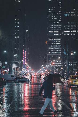 city man crossing on road under umbrella metropolis