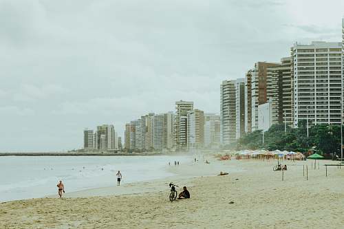 city man sitting beside bicycle on shore high rise