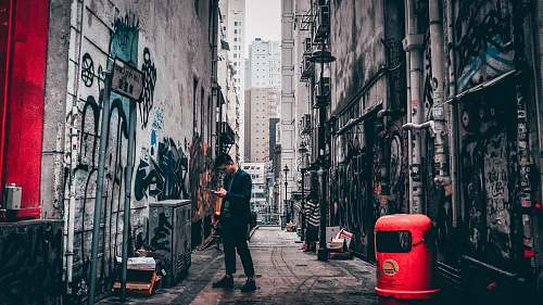 city man standing between buildings road