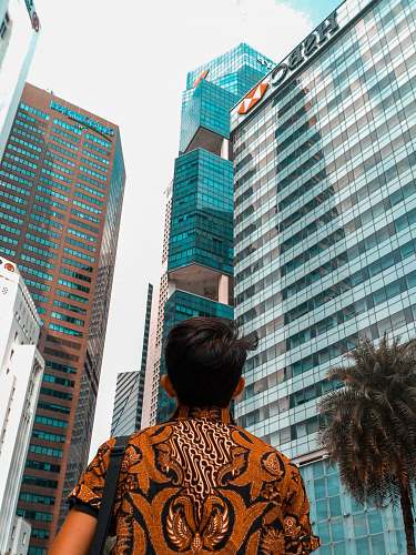 city man standing front of curtain wall building office building