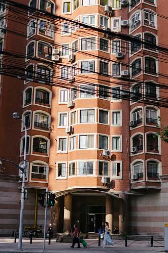 town people in front of brown building during daytime urban