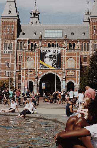 city people in front of brown concrete building downtown