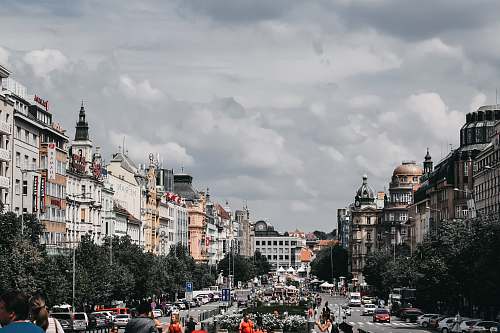 city people near road viewing city with high-rise buildings during daytime person