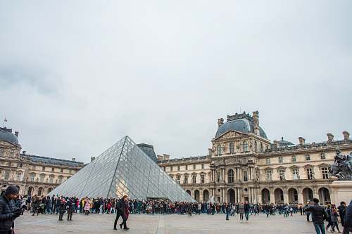 city people standing near Louvre Museum town