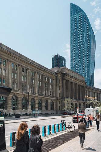 human people walking at the side of brown concrete buildinngg person