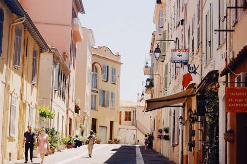 city people walking at the streets between buildings during day road