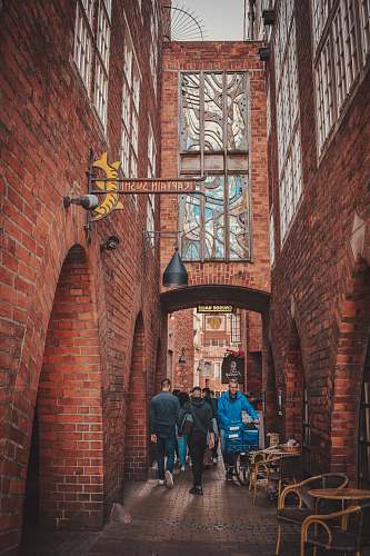 city people walking between building brick