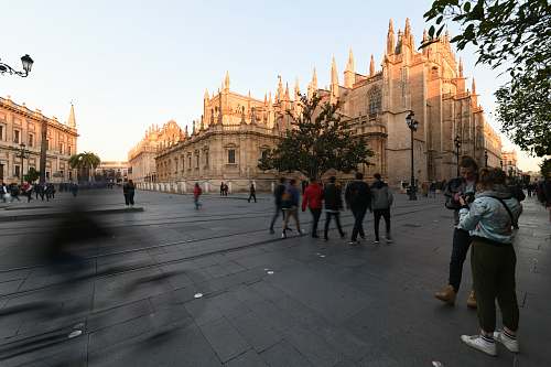 city people walking near brown concrete church during daytime downtown