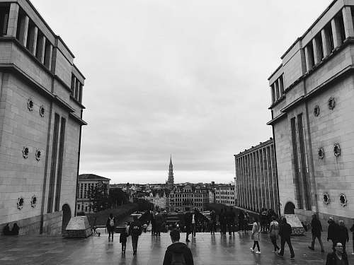 city people walking near buildings grayscale photo black-and-white