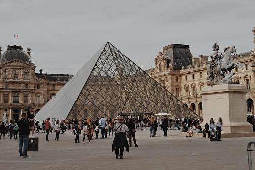 city people walking near Louvre Museum during daytime downtown