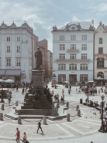 city people walking near statue downtown