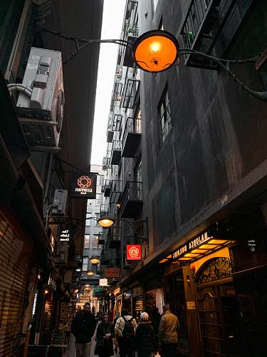 city people walking near street beside high-rise buildings during night time road