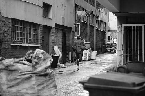 city person running along alley black-and-white
