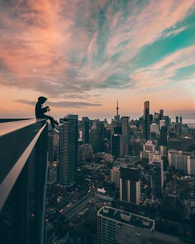 city person sitting on top of the building urban