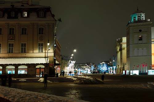 city person standing on road at night-time town