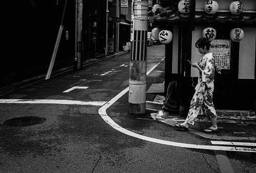 city person walking on street black-and-white