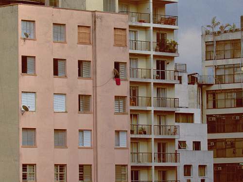 city pink and white concrete building during daytime close-up photography high rise