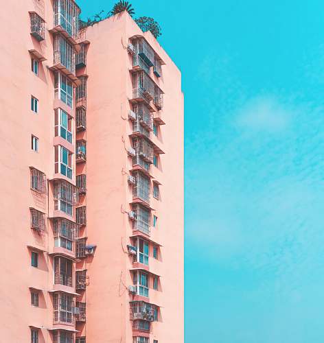 city pink condominium building across blue sky high rise