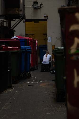 city sitting person beside container road