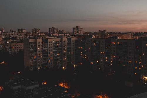 city tall buildings during golden hour with lights high rise