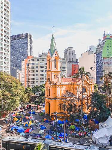 city tents in front of orange building during daytime downtown