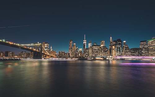 city turned on lights of buildings and bridge at night metropolis