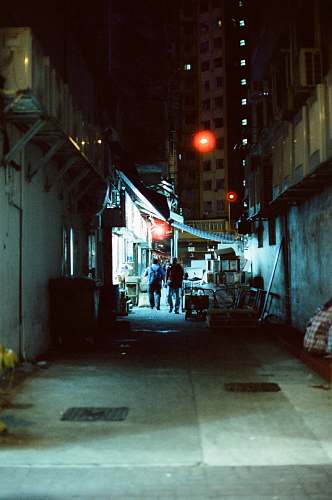 city two men walking along narrow road between buildings road