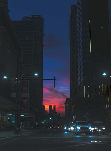 city vehicle on street between high-rise buildings during golden hour metropolis
