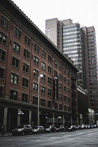 city vehicles park beside brown concrete building urban