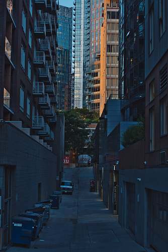 city vehicles parked in between concrete buildings urban