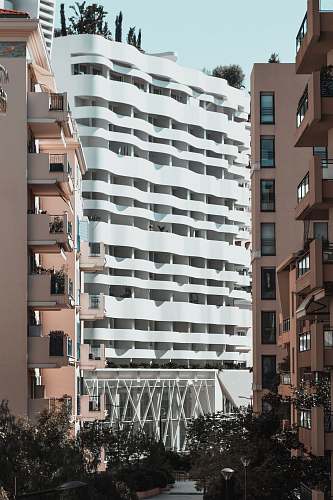city white concrete building beside two brown buildings high rise