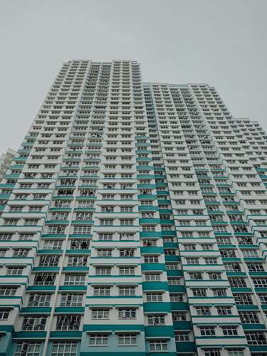 city worm view photo of white and teal building during daytime high rise