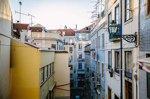 city yellow and white building at daytime alley