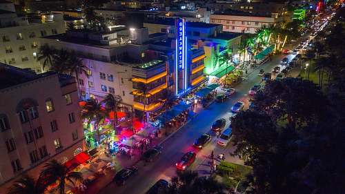 downtown aerial photography of vehicle traveling on road during nighttime town