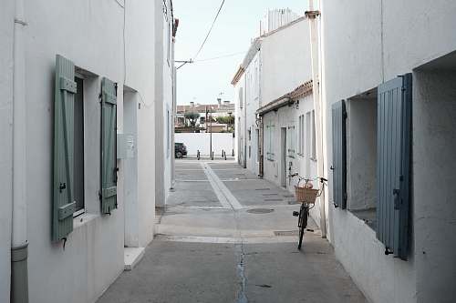 town bicycle parked on white building wall road