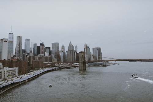 building buildings beside body of water under white sky high rise