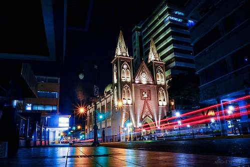 building city with high-rise buildings showing church during night time downtown
