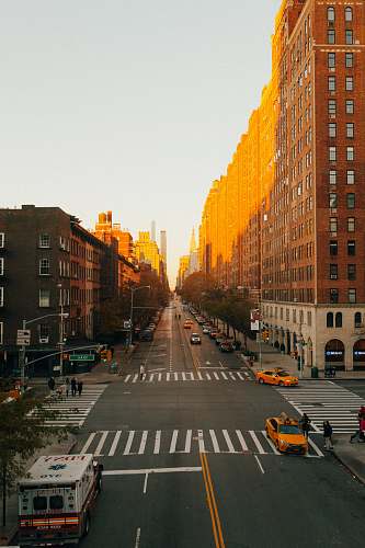 road concrete road beside building during golden hour vehicle
