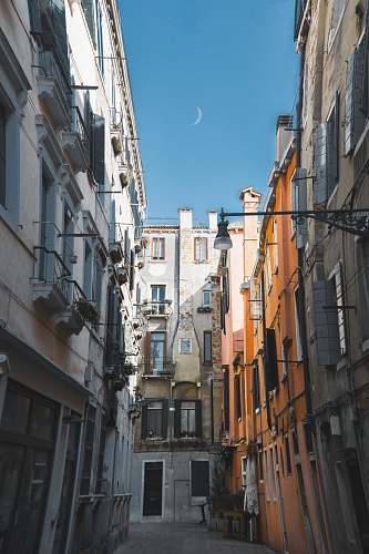 town concrete road in between buildings showing moon urban