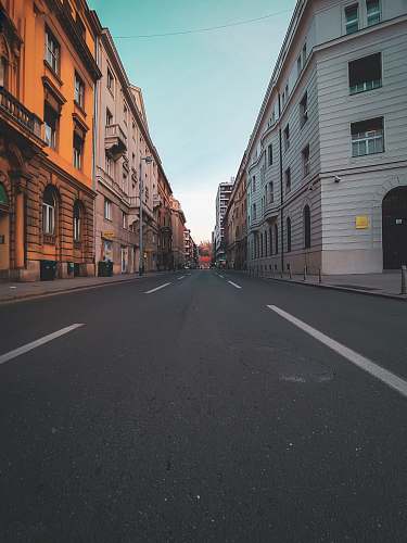 road concrete road in middle of buildings during daytime street