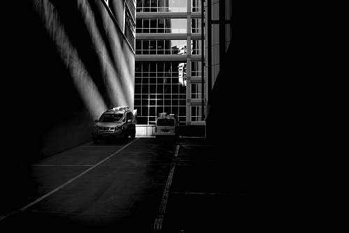 urban grayscale photo of parked silver SUV black-and-white