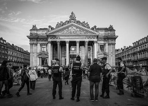 building grayscale photography of people standing near building black-and-white