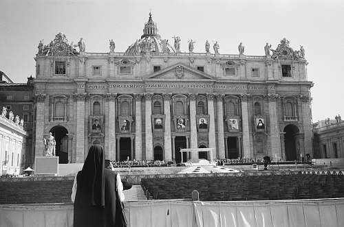 building grayscale photography of person standing near building black-and-white