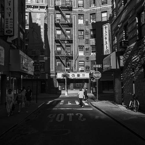 building grayscale photography of two women walking on road during daytime black-and-white