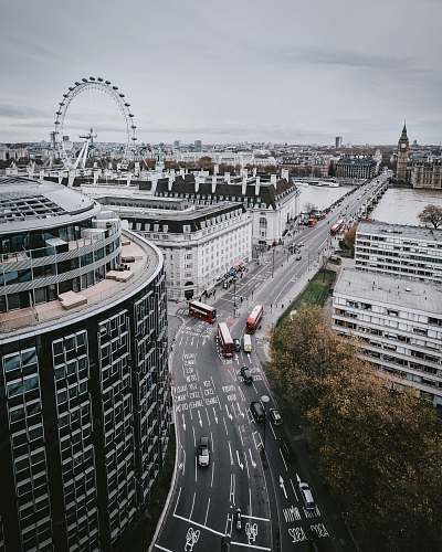 london high angle photography of vehicles passing on street surrounded with city buildings road