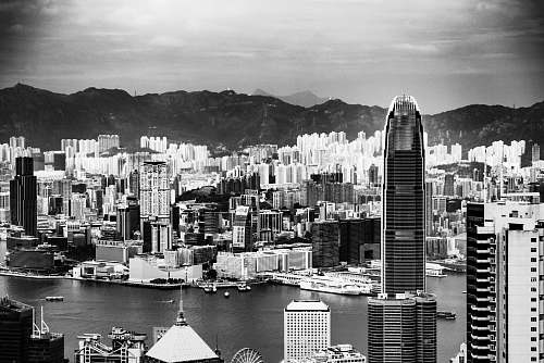 building high rise buildings with body of water and mountains black-and-white