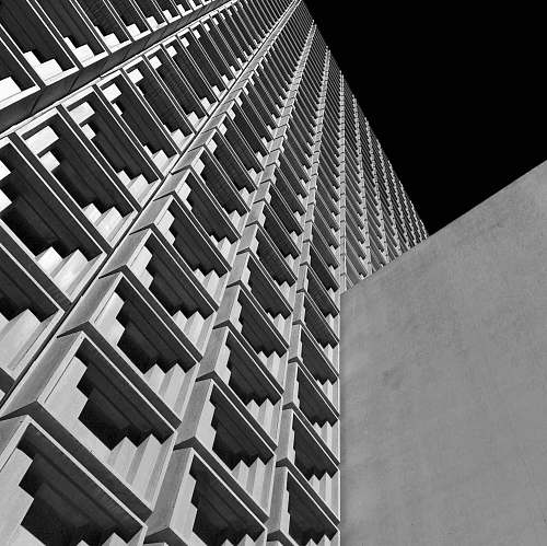 building low angle photo of white concrete building black-and-white