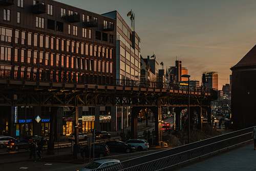 urban low-angle photography of cars on road by buildings town