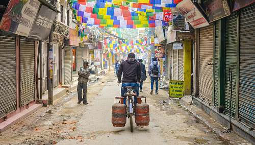 street man riding bike with two gas cylinders road